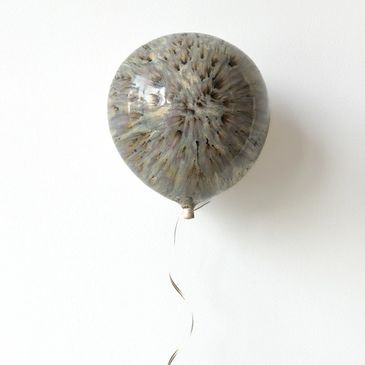 Round balloon with a unique, textured pattern and a curly ribbon.