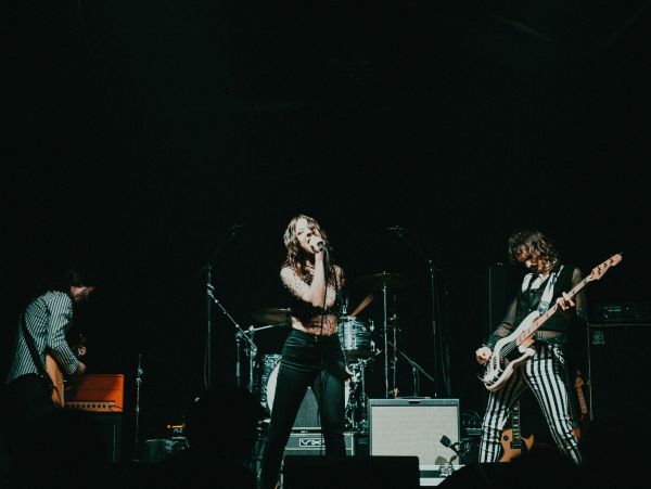 Band performing on stage with dramatic lighting and energetic presence.