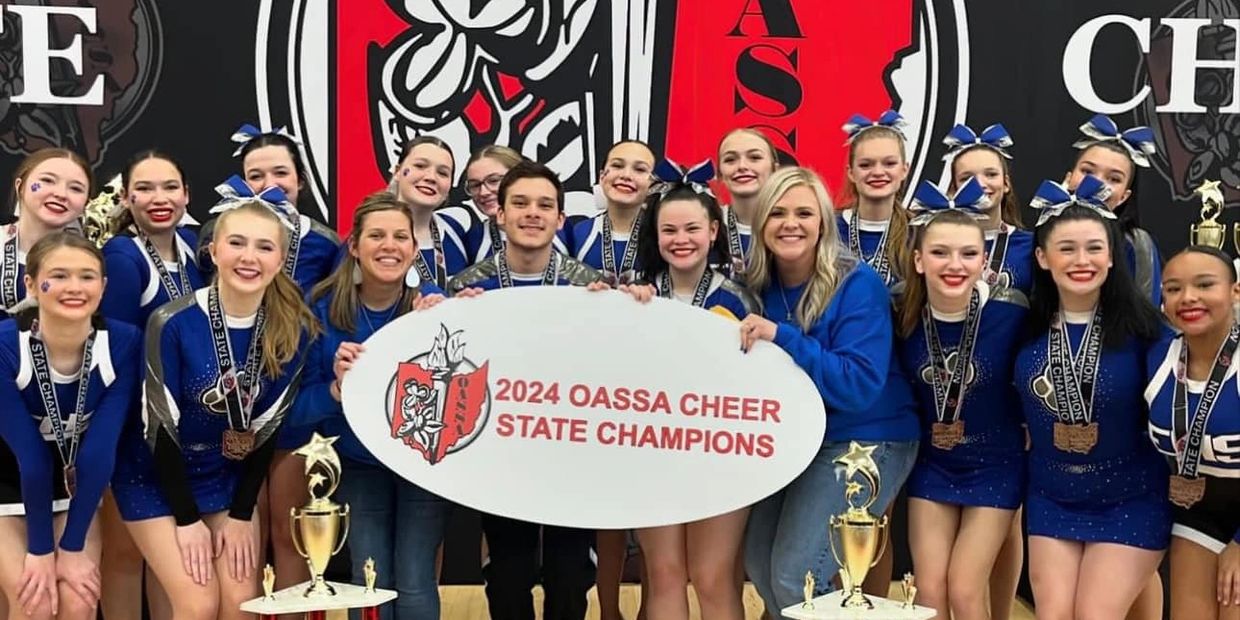 Cheerleading team celebrating 2024 OASSA State Championship victory with trophies and medals.