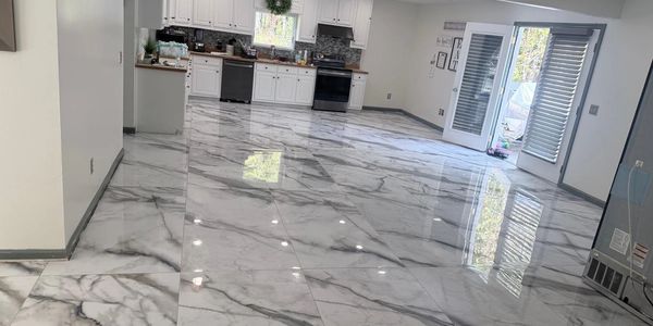 Spacious kitchen with glossy marble floors and white cabinetry.