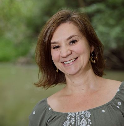 Smiling woman outdoors with natural background.
