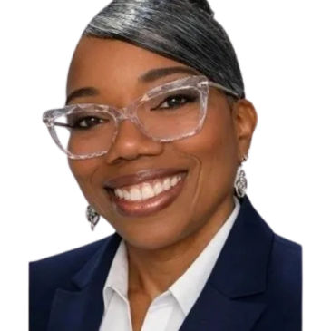 Professional woman smiling, wearing clear glasses and a navy blazer.