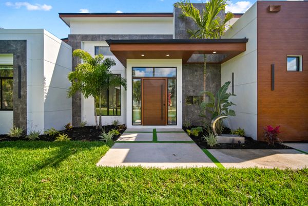 Modern house entrance with clean lines and tropical landscaping.