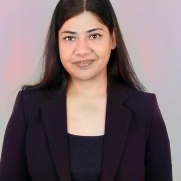 Professional woman smiling in a black blazer against a neutral background.
