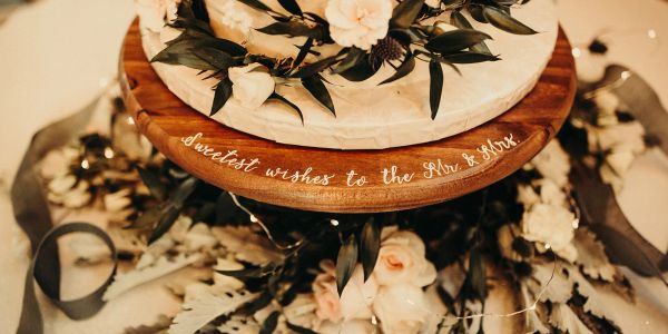 Cake with flowers and a message on a wooden base.