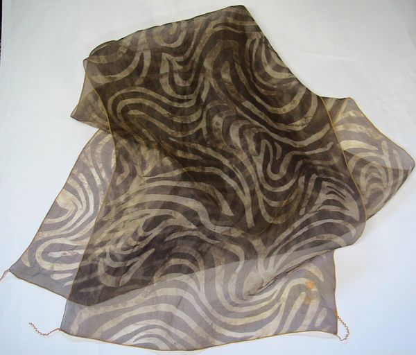 A silk scarf that is brown with wavy tan patterns