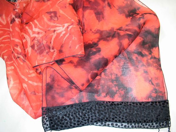 A vibrant red silk scarf with black trim.