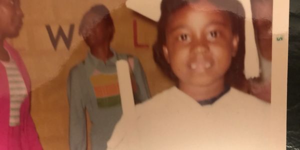 Rev. Karen wearing cap and gown at her kindergarten "graduation" from the daycare center at Jones Memorial Baptist Church.