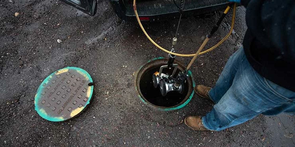 Man inspecting a catch basin