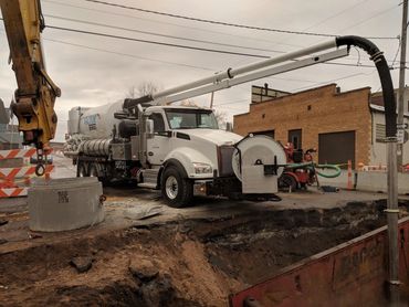 White work truck inspecting a pipe