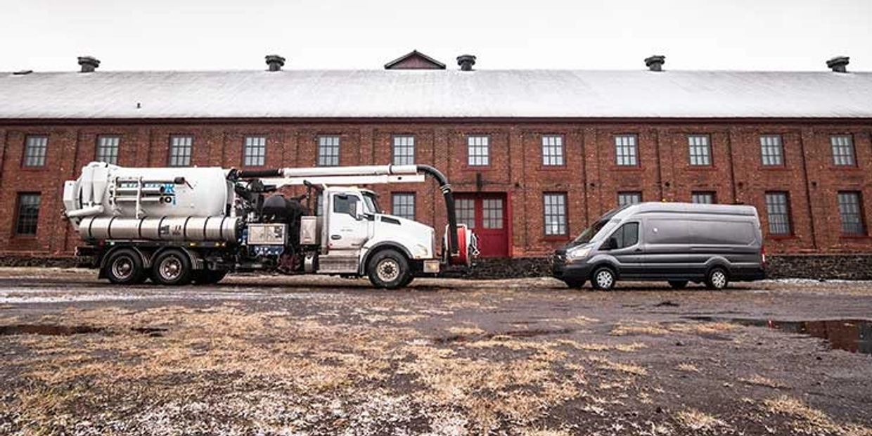 Two work trucks parked outside a building