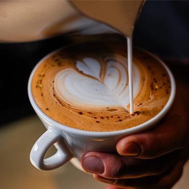 Close-up of latte art being poured into a coffee cup.