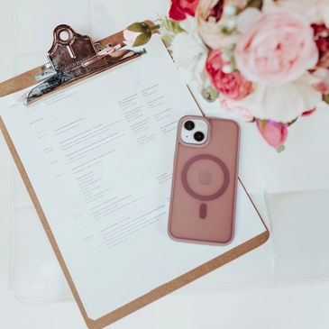 Wedding timeline with iPhone and flower centerpiece against white background