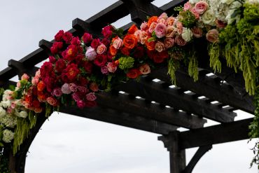 Colorful floral arrangement on a wooden pergola.