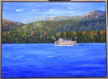 A boat on a lake with forested hills in the background.