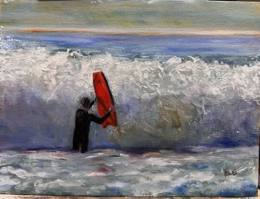 Person in wetsuit holding a red surfboard facing a big wave.