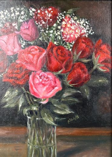 A bouquet of pink and red roses in a glass vase.