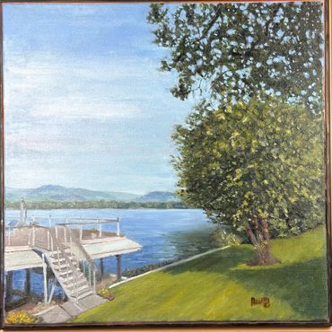 Lake view with dock and tree on grassy shore.