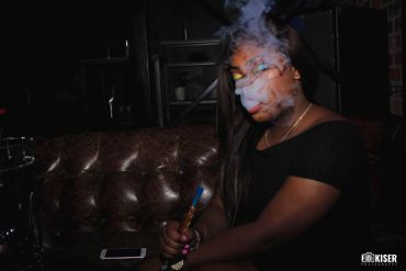 Person smoking a hookah in a dark setting.