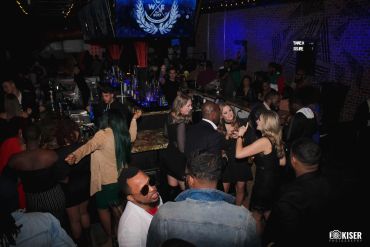 Crowded nightclub with people socializing and dancing.