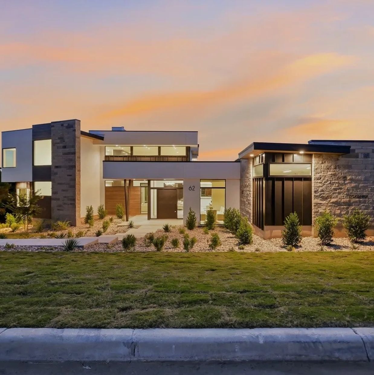 Modern house with large windows at sunset.