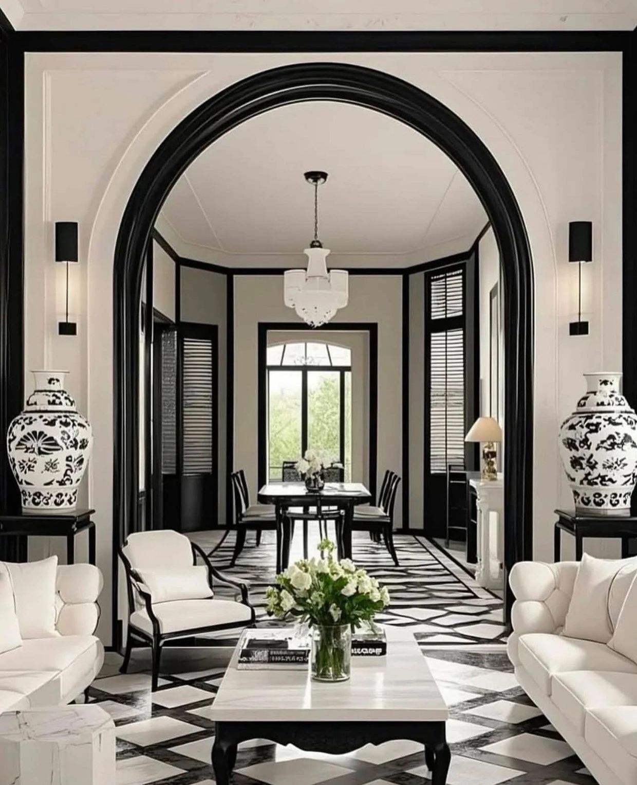 Elegant black and white living room with classic furniture and decorative vases.