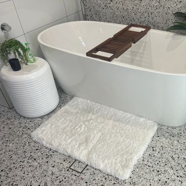 Modern bathroom with a white freestanding tub and terrazzo floor.