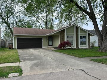 Single-story house with a two-car garage and large front windows.