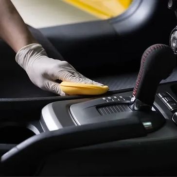 A detailer cleaning the front seat of a car.