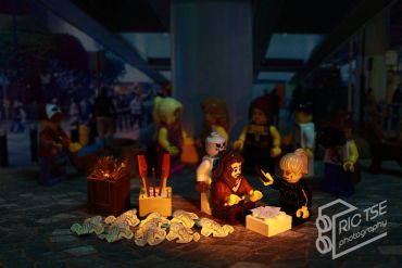 LEGO figures gathered around presents with birthday candles.