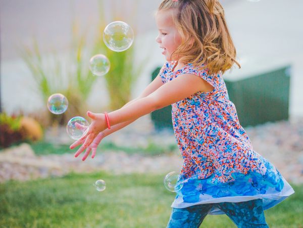 Photo of child playing with bubbles. 