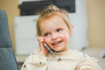 Photo of young child playing making a phone call. 