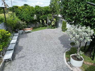 A spacious backyard patio with seating and greenery.