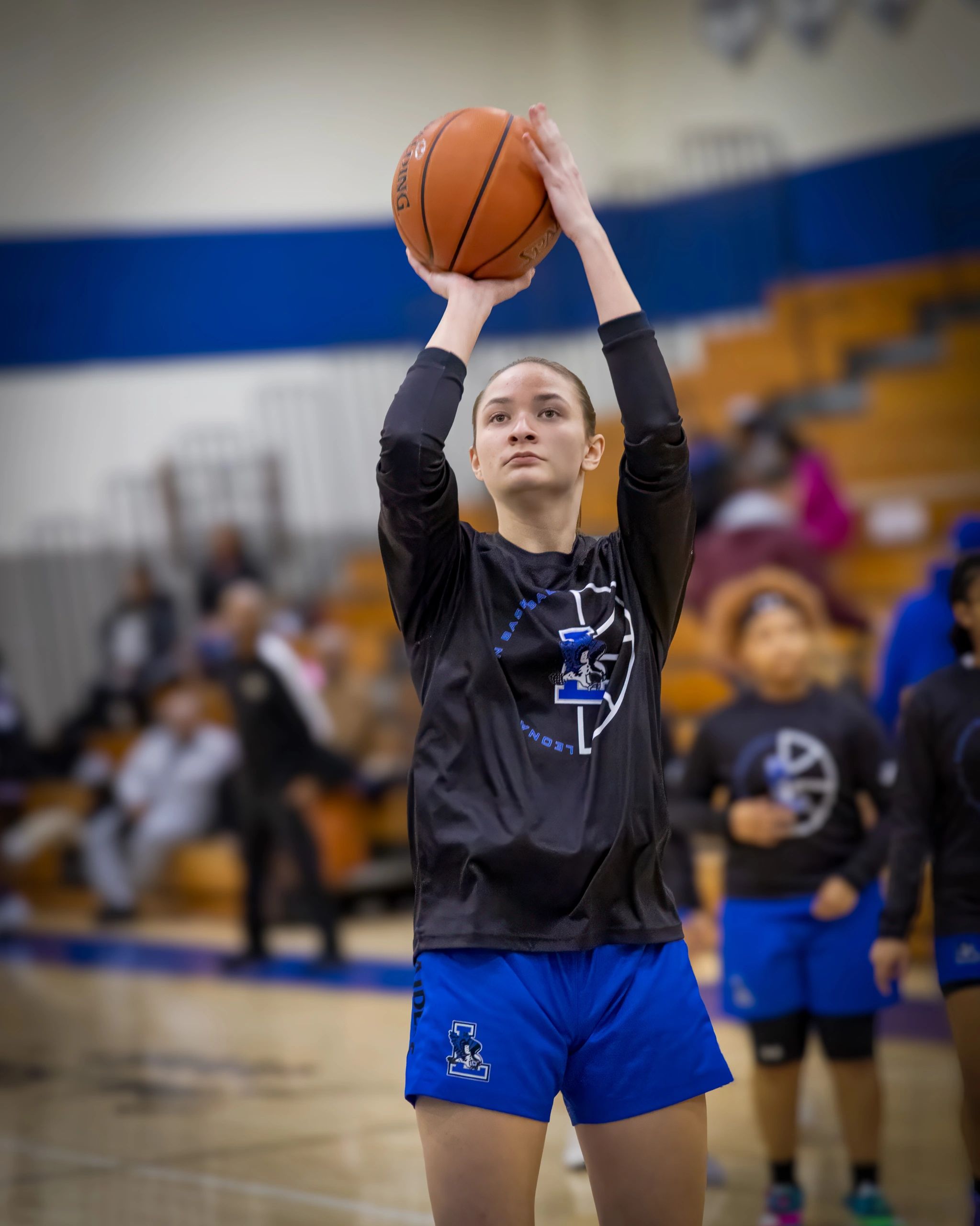 Young female basketball player taking a shot during warm-up.