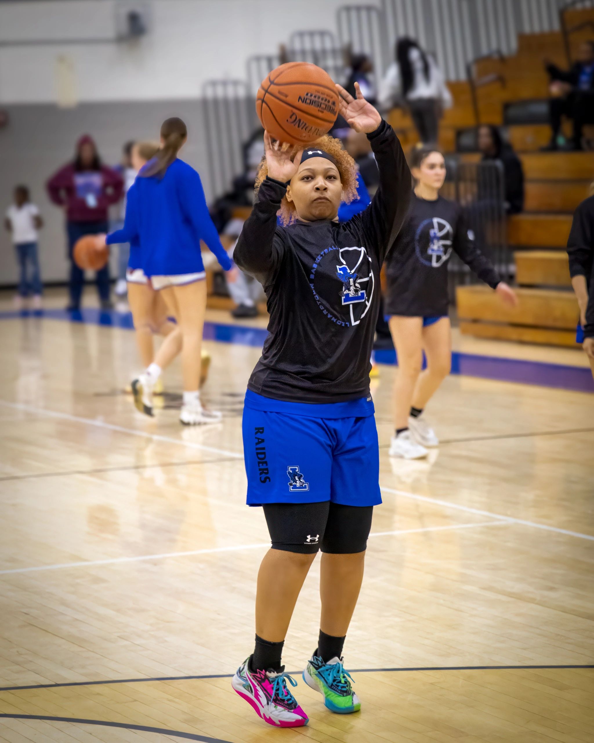 Female basketball player practicing her shot on the court.