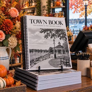 A town book titled 'TOWN BOOK' displayed in a cozy autumn setting.