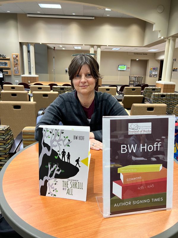 Author BW Hoff at a book signing event with her book displayed.