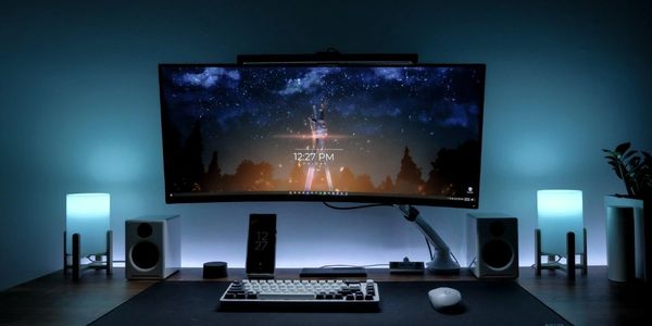 Sleek, modern computer setup with ambient blue lighting and an ultra-wide monitor.