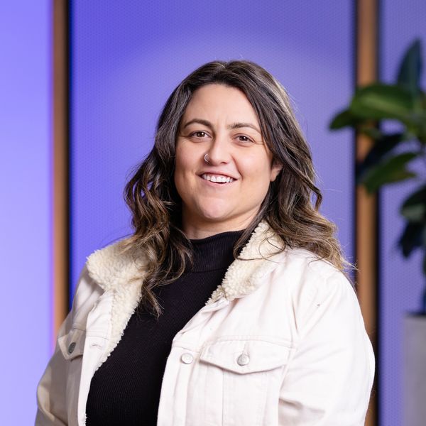 Smiling woman wearing a white jacket and black top.