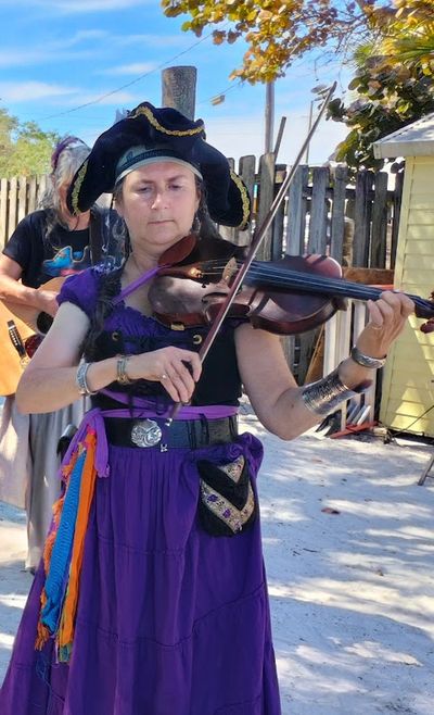 Woman playing violin in pirate garb.