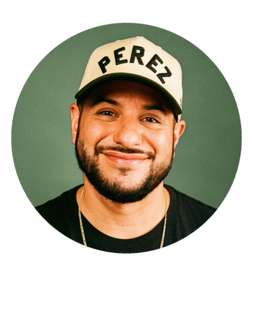 Photo of PEREZ wearing a Cream and Heather hat that reads "PEREZ" and a black t-shirt.