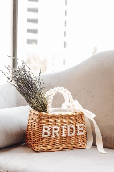 Wicker bride bag with pearl handle and lavender.