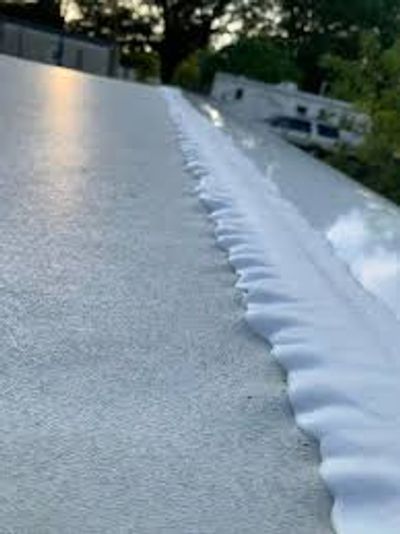 Close-up of a white foam strip on a flat roof surface.
