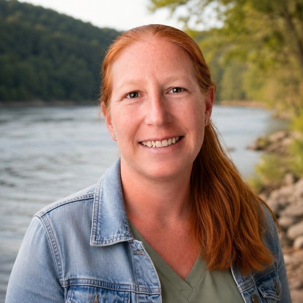 Woman standing by river smiling
