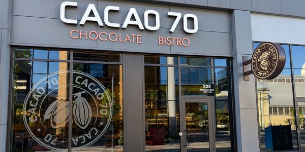 Front view of CACAO 70 Chocolate Bistro with logo on glass and signboard.