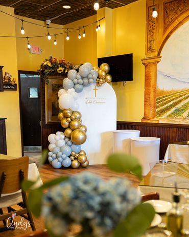Elegant balloon decoration in gold, white, and gray for a special religious event.