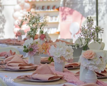 Elegant table setting with pink napkins and floral centerpieces for a celebration.