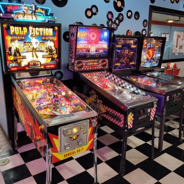 Row of retro pinball machines including Pulp Fiction.