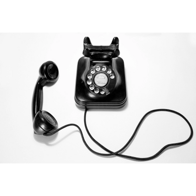 Black vintage rotary dial telephone with handset off the hook.