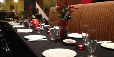 Elegant dining table set with plates, glasses, and flowers.